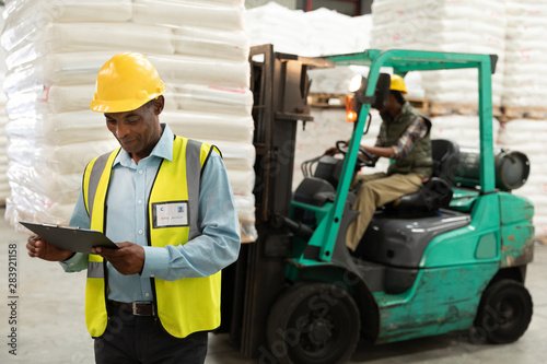 Male worker looking at clipboard in warehouse