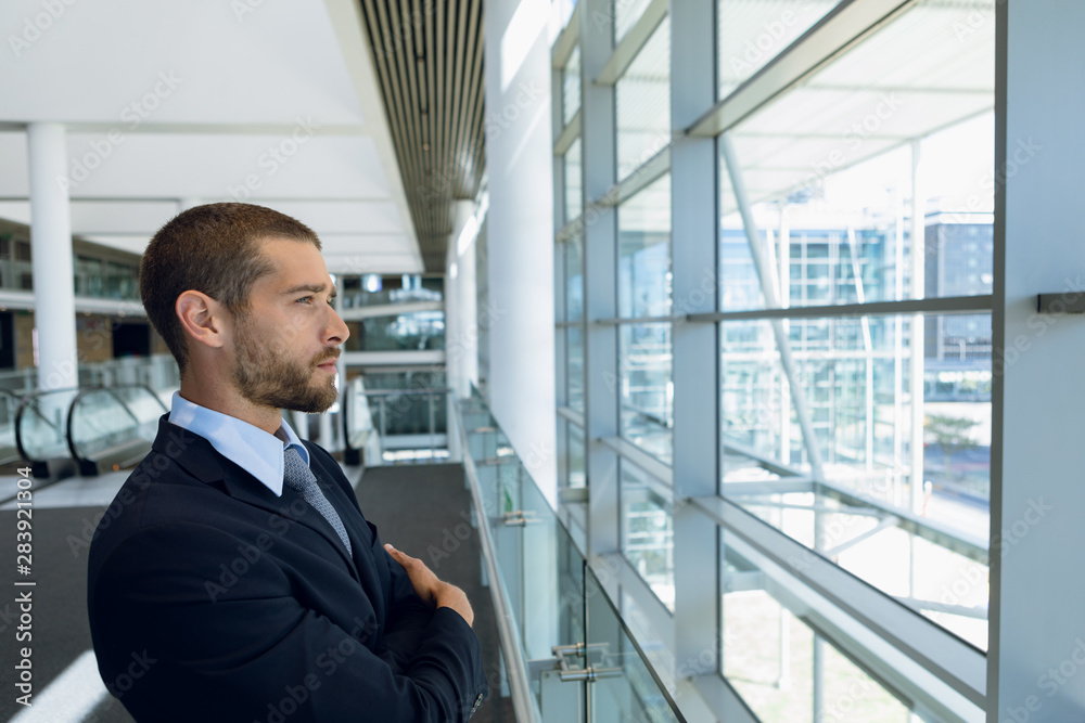 Businessman looking out of window in office lobby