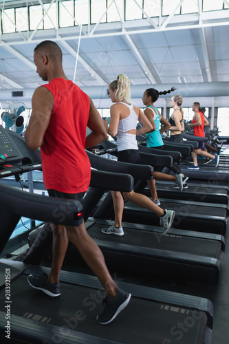 Fit people exercising on treadmill in fitness center