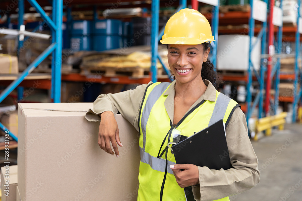 female-staff-smiling-while-standing-in-warehouse-stock-photo-adobe-stock