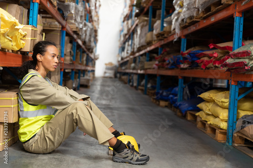 Female staff sitting on floor in warehouse