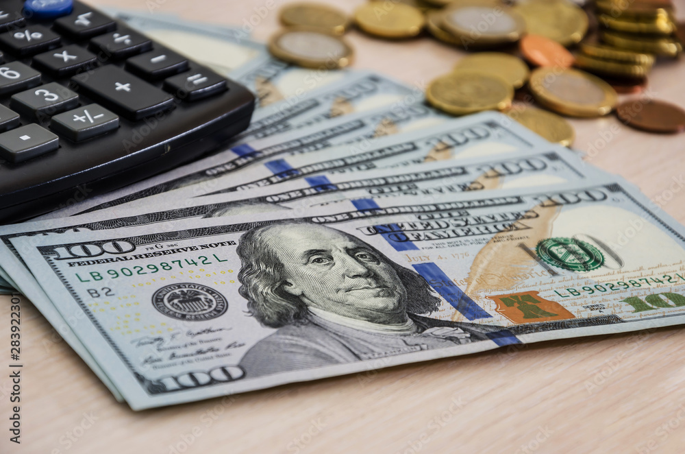 Fototapeta premium dollars, coins and calculator on the table, close-up