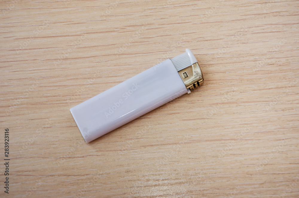 white lighter on a wooden background. View from above. white lighter on a wooden background. View from above.