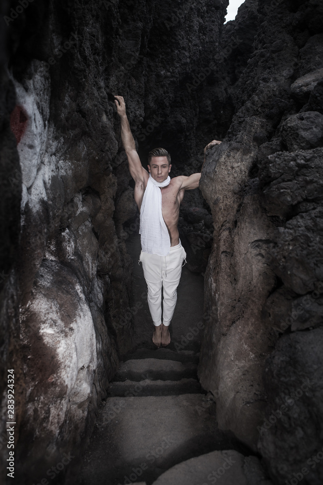 Taut man standing at bottom of cave Taut man standing at bottom of cave