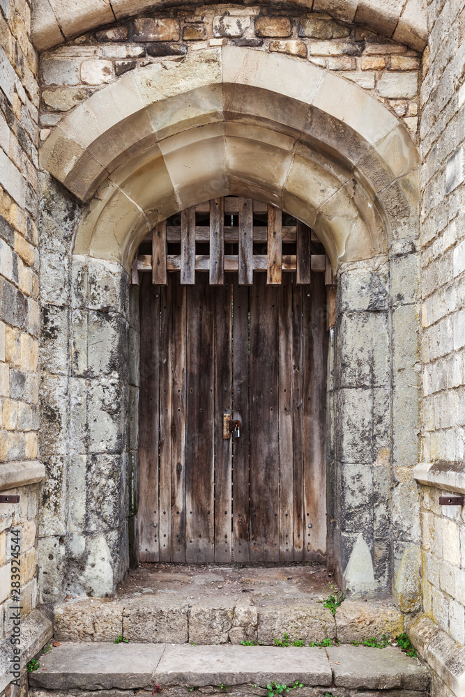 Locked wooden door in old fortification wall