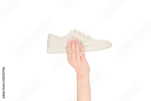 White leather shoes in woman hand isolated on white.