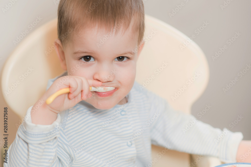 baby in the kitchen eating fruit puree baby in the kitchen eating fruit puree