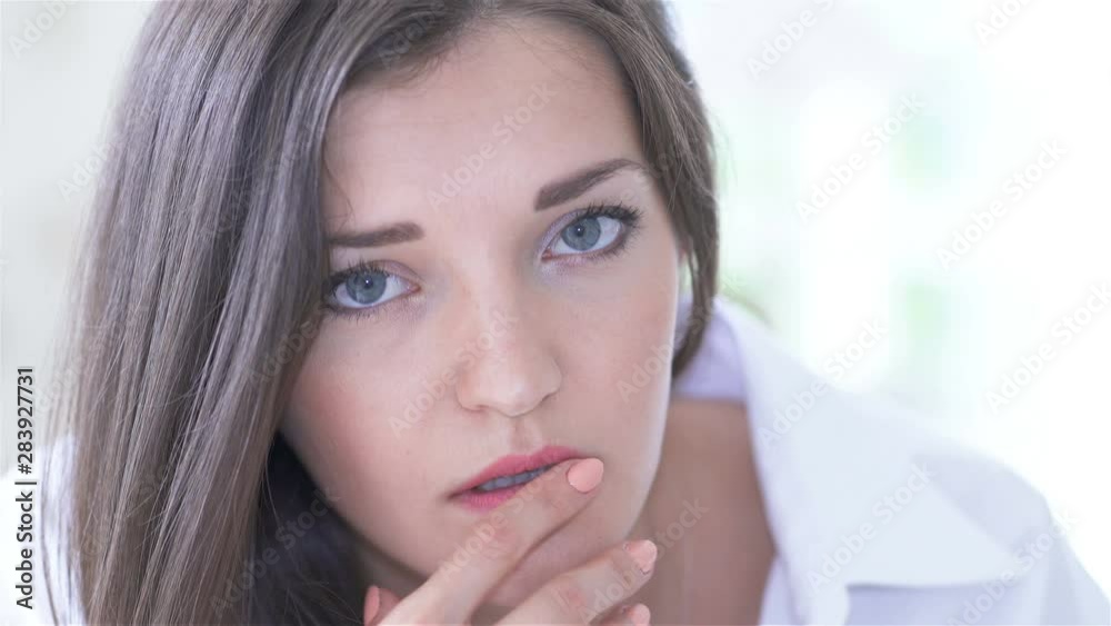 4K. Young sexy seductive woman model lies on bed, looking on camera, face close up 4K. Young sexy seductive woman model lies on bed, looking on camera, face close up