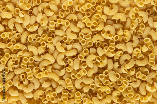 A lot of elbow macaroni shape of italian pasta as background on banner