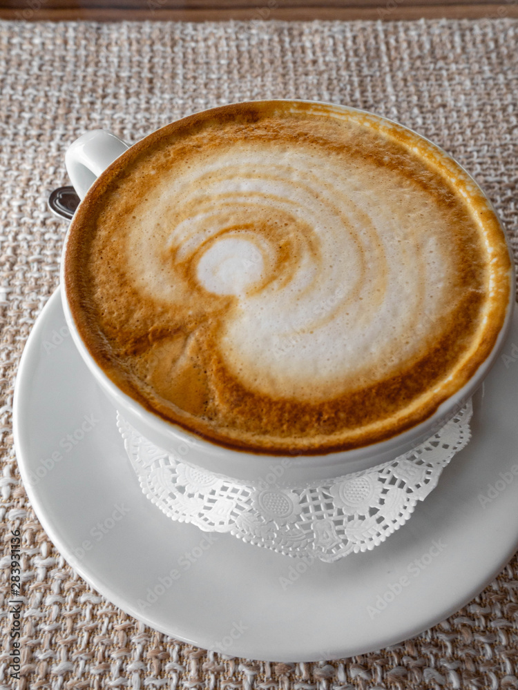 coffee cappuccino or latte in white elegant cup with saucer, on rustic sackcloth a background. Morning hot beverage. Coffee lifestyle. coffee cappuccino or latte in white elegant cup with saucer, on rustic sackcloth a background. Morning hot beverage. Coffee lifestyle.