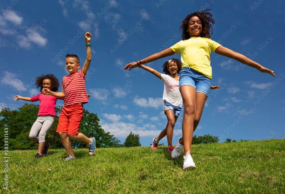 Group of kids run downhill with happy expression