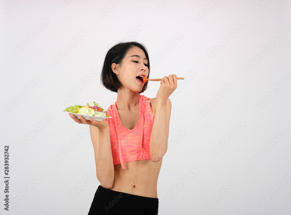 sporty fitness woman in sportswear with vegetable salad on white background. healthy sport sporty fitness woman in sportswear with vegetable salad on white background. healthy sport