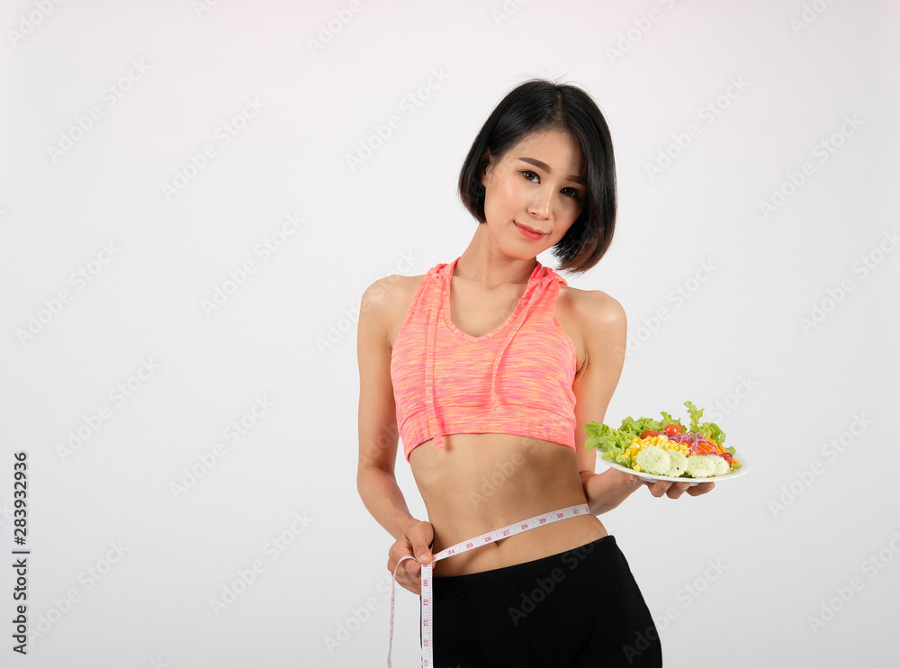 sporty fitness woman in sportswear with vegetable salad on white background. healthy sport sporty fitness woman in sportswear with vegetable salad on white background. healthy sport