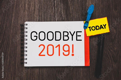Writing note showing Goodbye 2019. Business photo showcasing New Year Eve Milestone Last Month Celebration Transition Open notebook white page clothespin holding reminder wooden background photo