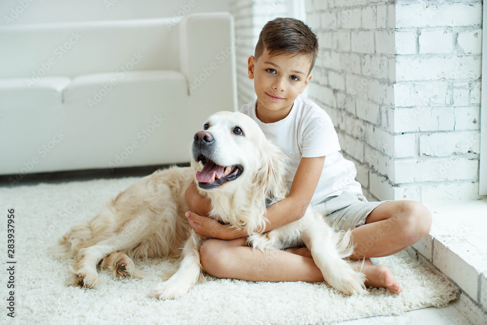 A child with a dog. Teen boy with a dog at home. A child with a dog. Teen boy with a dog at home.