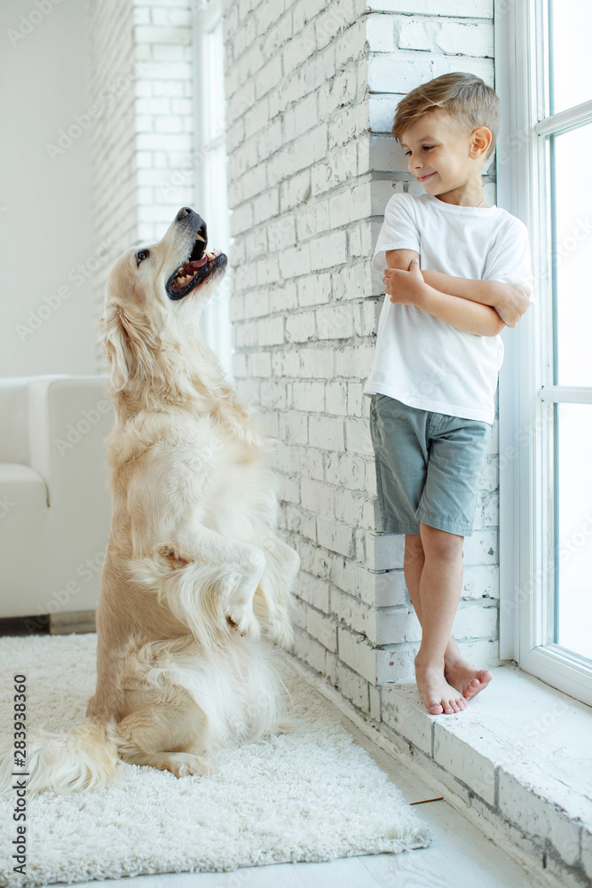 Φωτογραφία Children with a dog. Little boy at home with a dog.