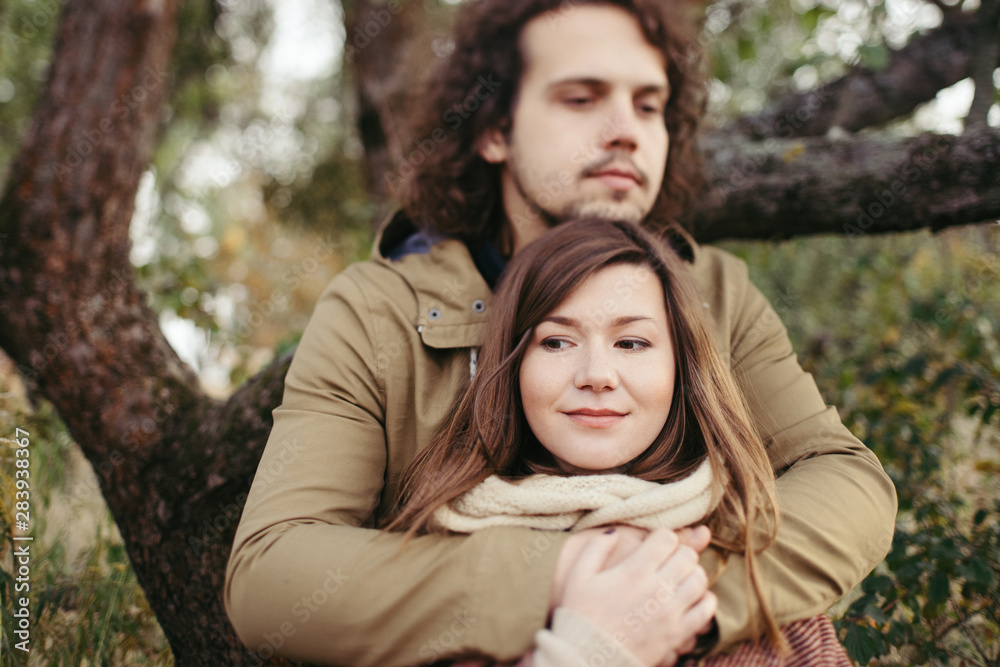 Young happy caucasian couple expecting a baby. Pregnant woman and her husband walking and having fun together outdoors in the autumn. Family, parenthood, love, happiness concept. Young happy caucasian couple expecting a baby. Pregnant woman and her husband walking and having fun together outdoors in the autumn. Family, parenthood, love, happiness concept.