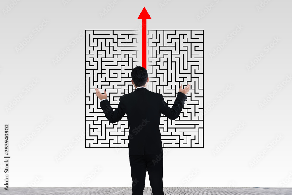 Businessman in doubt looking to a maze and searching the way out Businessman in doubt looking to a maze and searching the way out