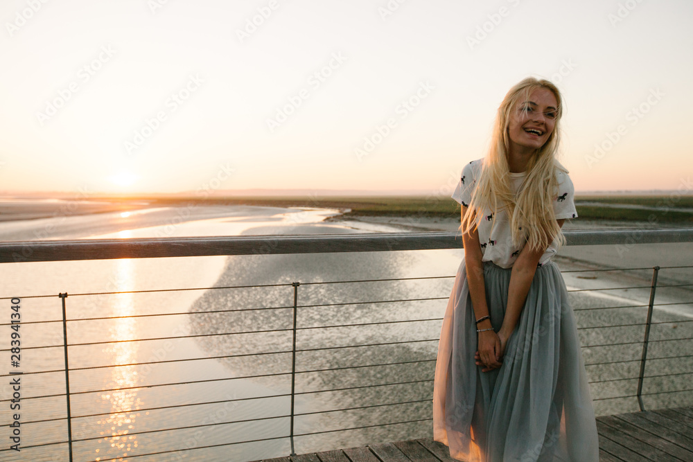 Fototapeta premium Beautiful woman walking on the ocean beach in Normandy, France