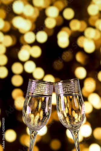 Close-up of champagne glasses on bokeh light background