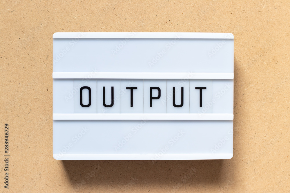 White lightbox with word output on wood background
