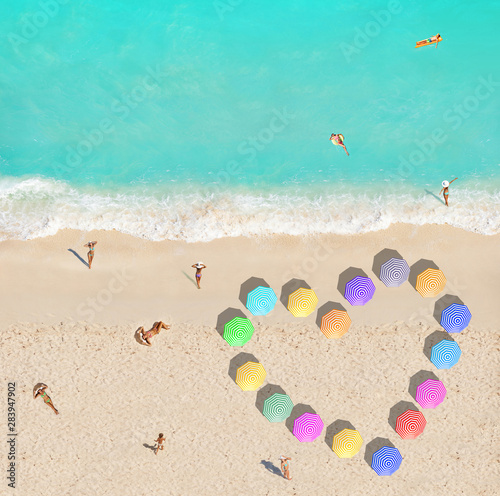People on beach and heart shape made of umbrellas
