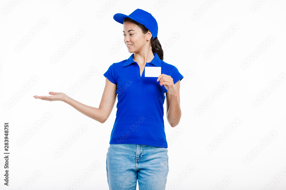 Young deliverer poses with a card as if she holds something. Young deliverer poses with a card as if she holds something.