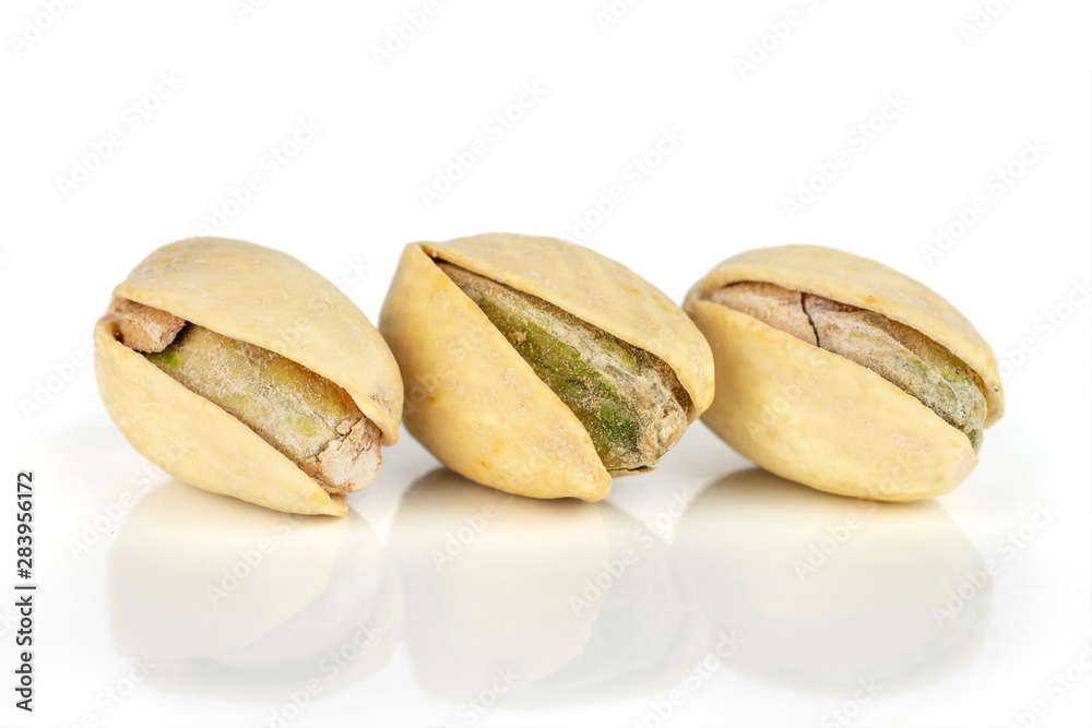 Group of three whole ripe green pistachio with shell in closeup in row isolated on white background Group of three whole ripe green pistachio with shell in closeup in row isolated on white background
