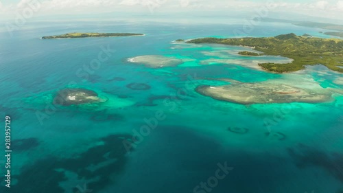 Islands are surrounded by an atoll and a coral reef with blue water top view. Bucas grande, Philippines. Summer and travel vacation concept. photo