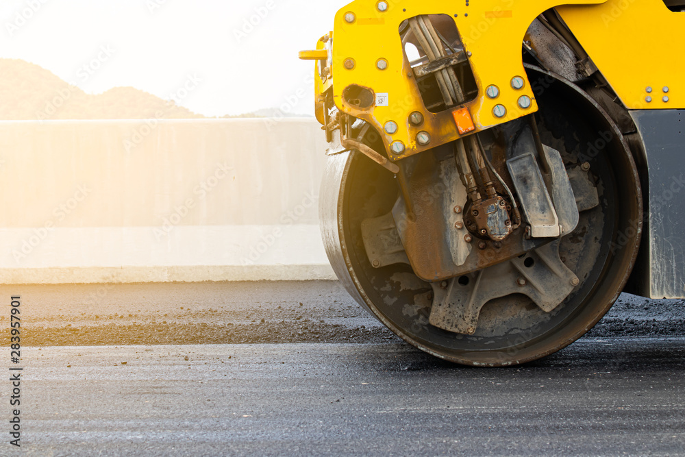 Asphalt road surface is smoothed with steel wheels, road construction machinery, asphalt paver Asphalt road surface is smoothed with steel wheels, road construction machinery, asphalt paver