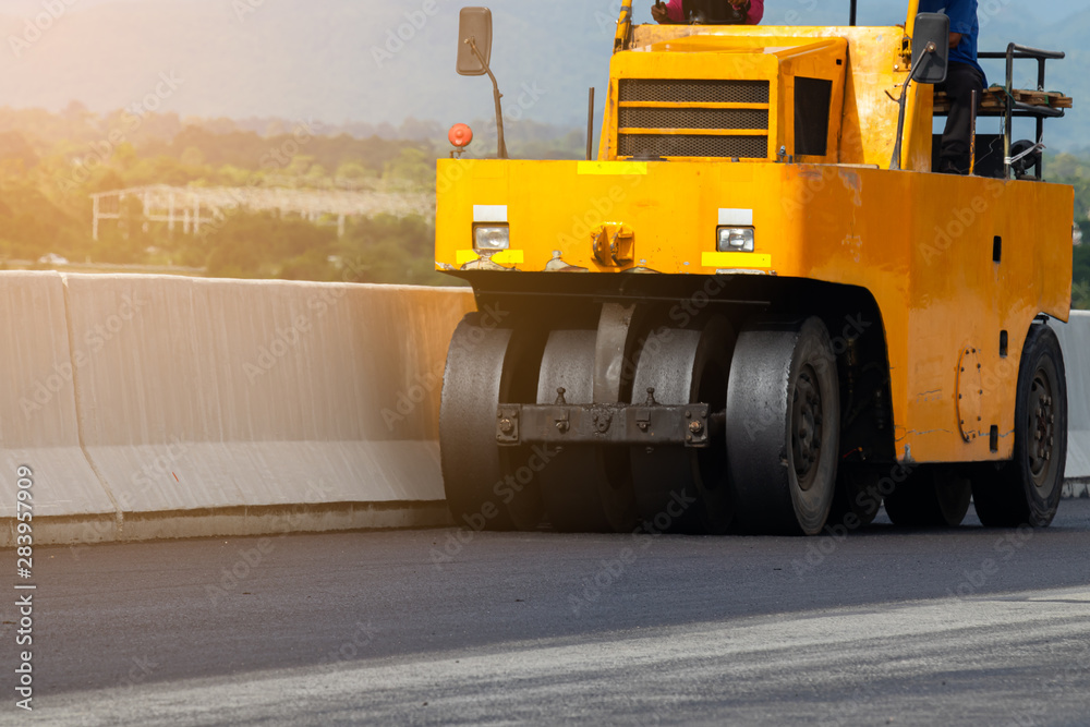 Asphalt road surface is tightened with vibratory compactors, rubber ...