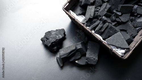 Close-up images of black color charcoal on black background that made from natural wood which represent energy power concept or healthy or use for absorb odor in the room or refrigerator.