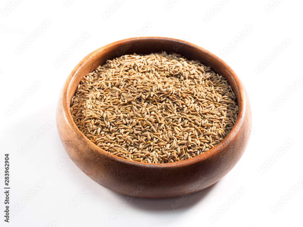 Cumin seeds (Cuminum), jeera in a wooden cup on a white background Cumin seeds (Cuminum), jeera in a wooden cup on a white background