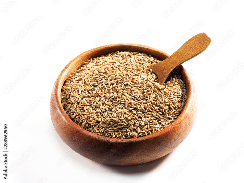 Cumin seeds (Cuminum), jeera and wooden scoop in cup on a white background Cumin seeds (Cuminum), jeera and wooden scoop in cup on a white background