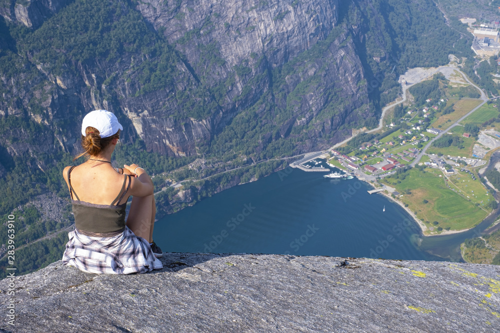 Girl sitting admiring the landscape over Lysefjord in Norway