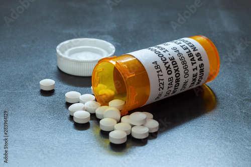 Prescription bottle with backlit Oxycodone tablets. Oxycodone is a generic prescription opioid. A concept of the opioid epidemic crisis photo