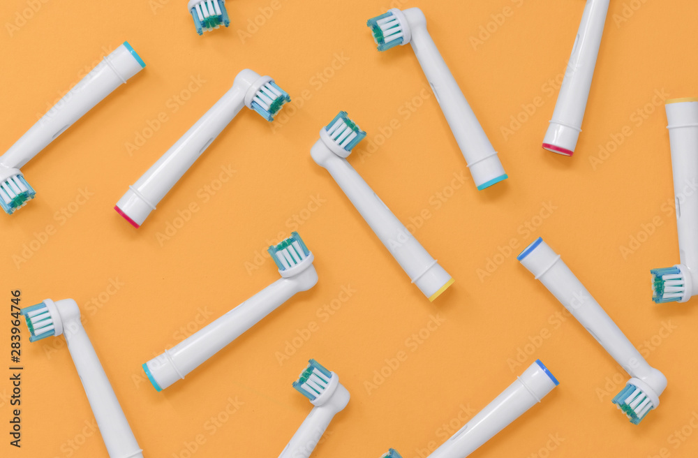 Obraz premium Pattern of electric toothbrush heads on an orange background