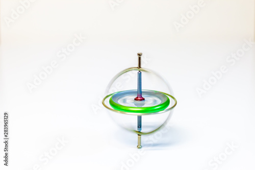 A spinning metal toy gyroscope isolated on a white background