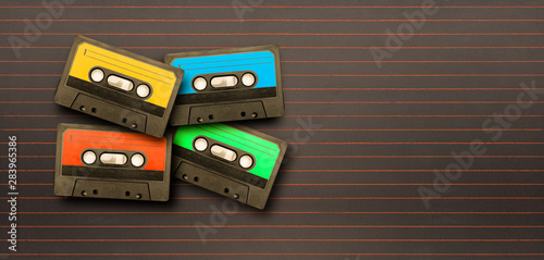 Alte Musikkasetten in verschiednenen Farben auf einer alten Schultafel