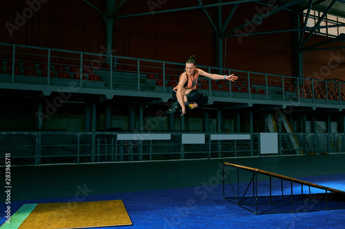 The young woman performs a trick. Jump. Indoor training