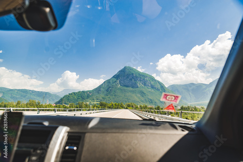 car travel concept view from front passenger seat highway with mountains straight ahead