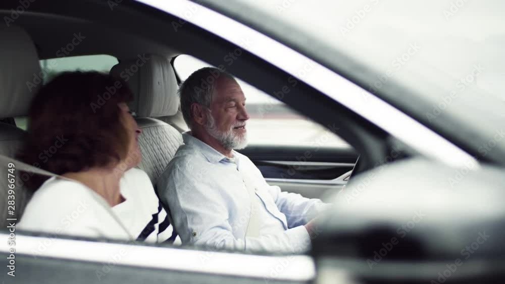 Happy senior couple sitting in car, talking. Happy senior couple sitting in car, talking.