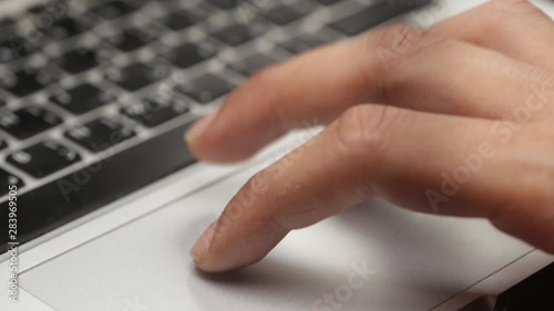 closeup of a man's hand using the trackpad on a laptop 