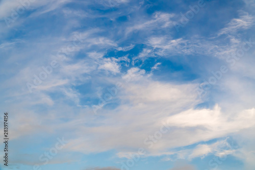 White clouds on a background of blue sky on a sunny day. Summer season, august.