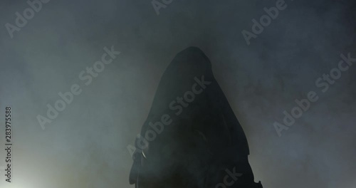 Silloutte Of Blonde Female Boxer Wearing Boxing Robe In Smoke. Preparing To Go Out And Fight. Looking Up at Her Supporters. Before A Fight , Lit By Studio Lights Behind Her. photo