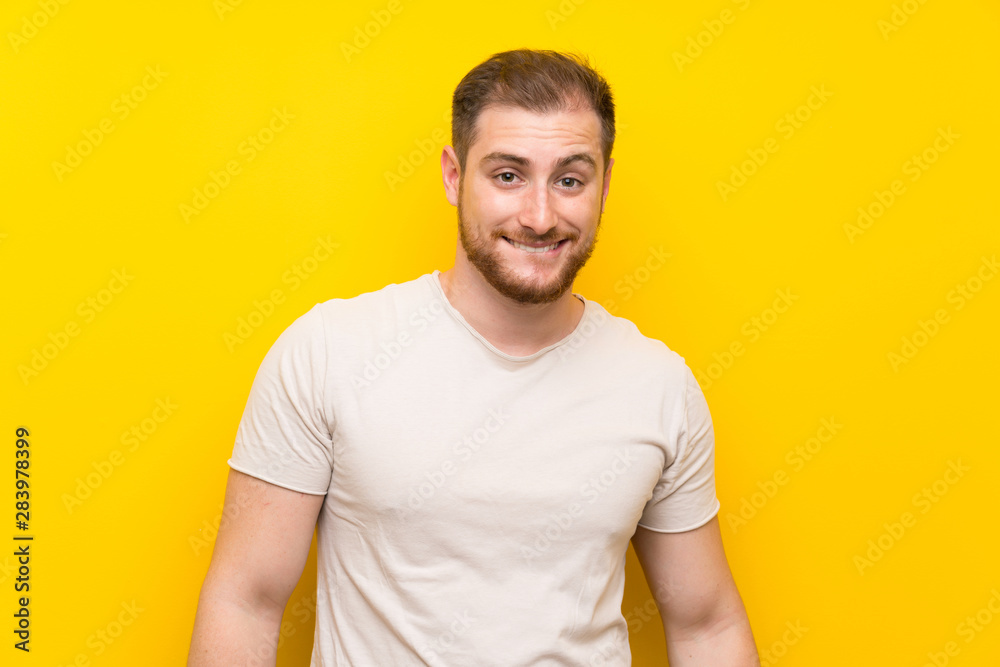 Handsome man over yellow background having doubts and with confuse face expression Handsome man over yellow background having doubts and with confuse face expression