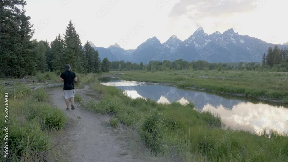 Man hiking in Grand Tetons National park at sunset in Wyoming