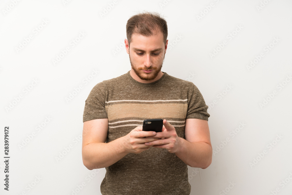 Handsome man over isolated white wall using mobile phone Handsome man over isolated white wall using mobile phone