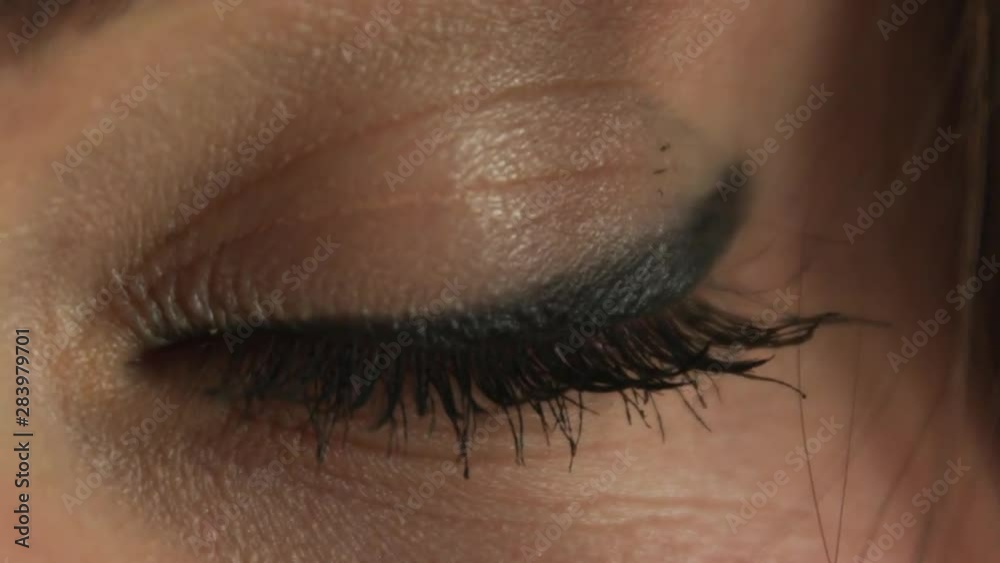 Close-up of a young Caucasian girl's green eye closing and opening Close-up of a young Caucasian girl's green eye closing and opening