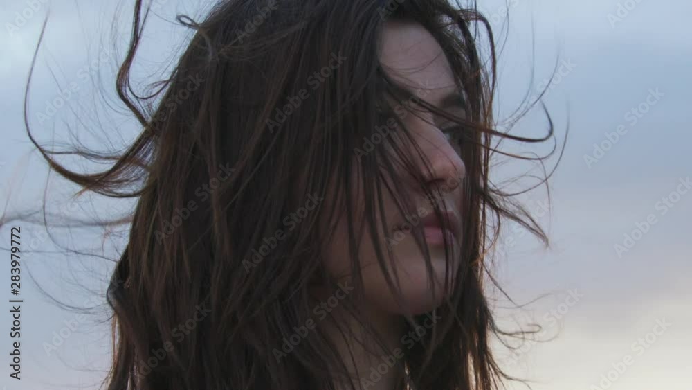 Caucasian girl standing outside during windy weather Caucasian girl standing outside during windy weather